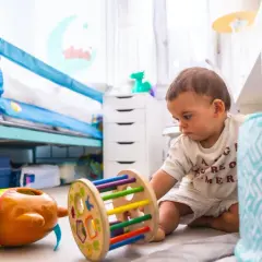 Jedno dziecko bawi się zabawkami w pokoju. W żłobku zazwyczaj jest więcej dzieci w grupie.