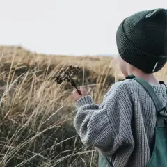 Jesienią w góry dziecko ubierz ciepło: czapka z uszkami, sweter i ogrodniczki.