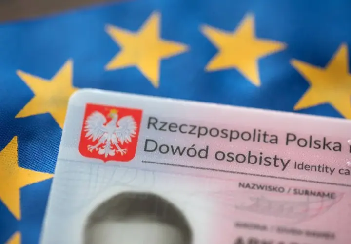 Polski dowód osobisty na tle flagi Unii Europejskiej.