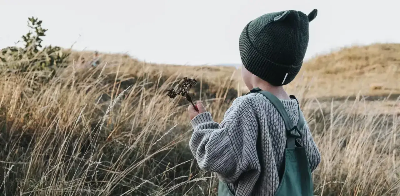 Jesienią w góry dziecko ubierz ciepło: czapka z uszkami, sweter i ogrodniczki.